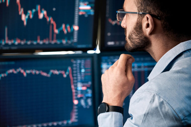 Man monitoring stock market screens